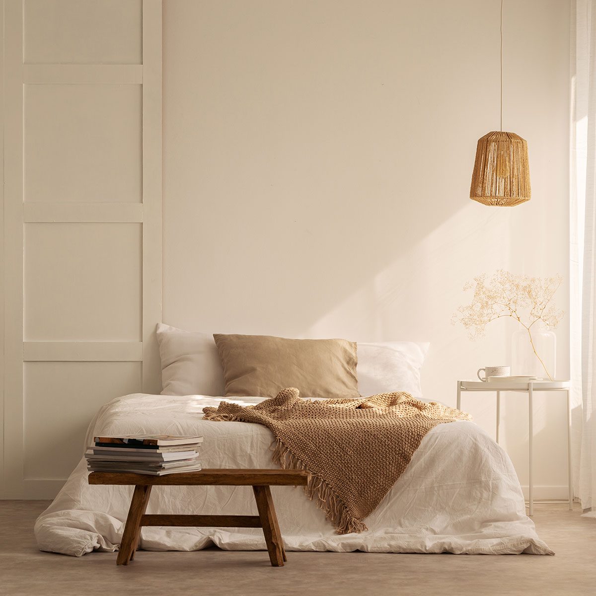 Beige Bedroom with blankets on double bed in stylish wabi sabi bedroom