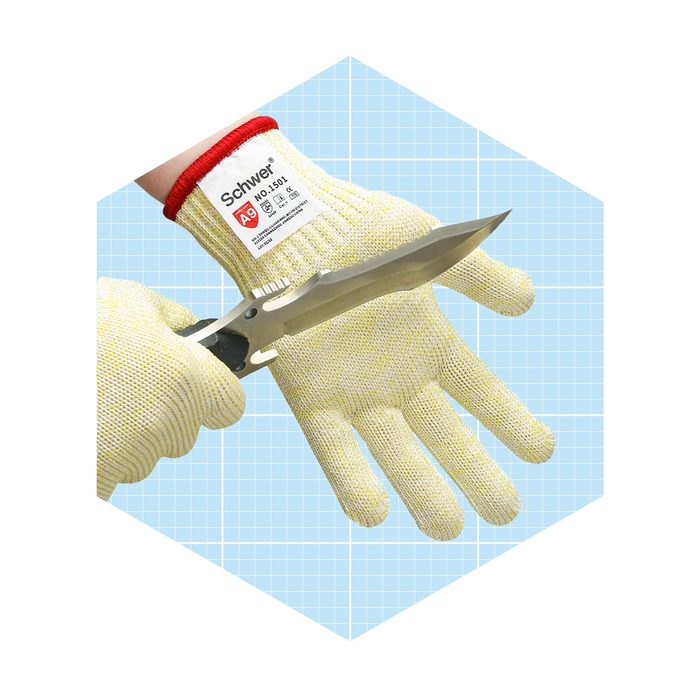 A gloved hand holds a knife, showcasing protective gear. The background features a light blue grid pattern, emphasizing the focus on safety equipment.