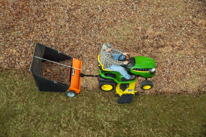 top view of a man on a tractor using a Agri Fab Lawn Sweeper