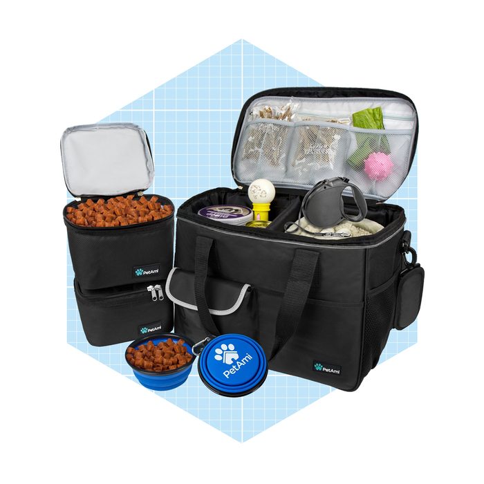 A black pet travel bag contains compartments filled with pet food and accessories, set against a light blue grid background.