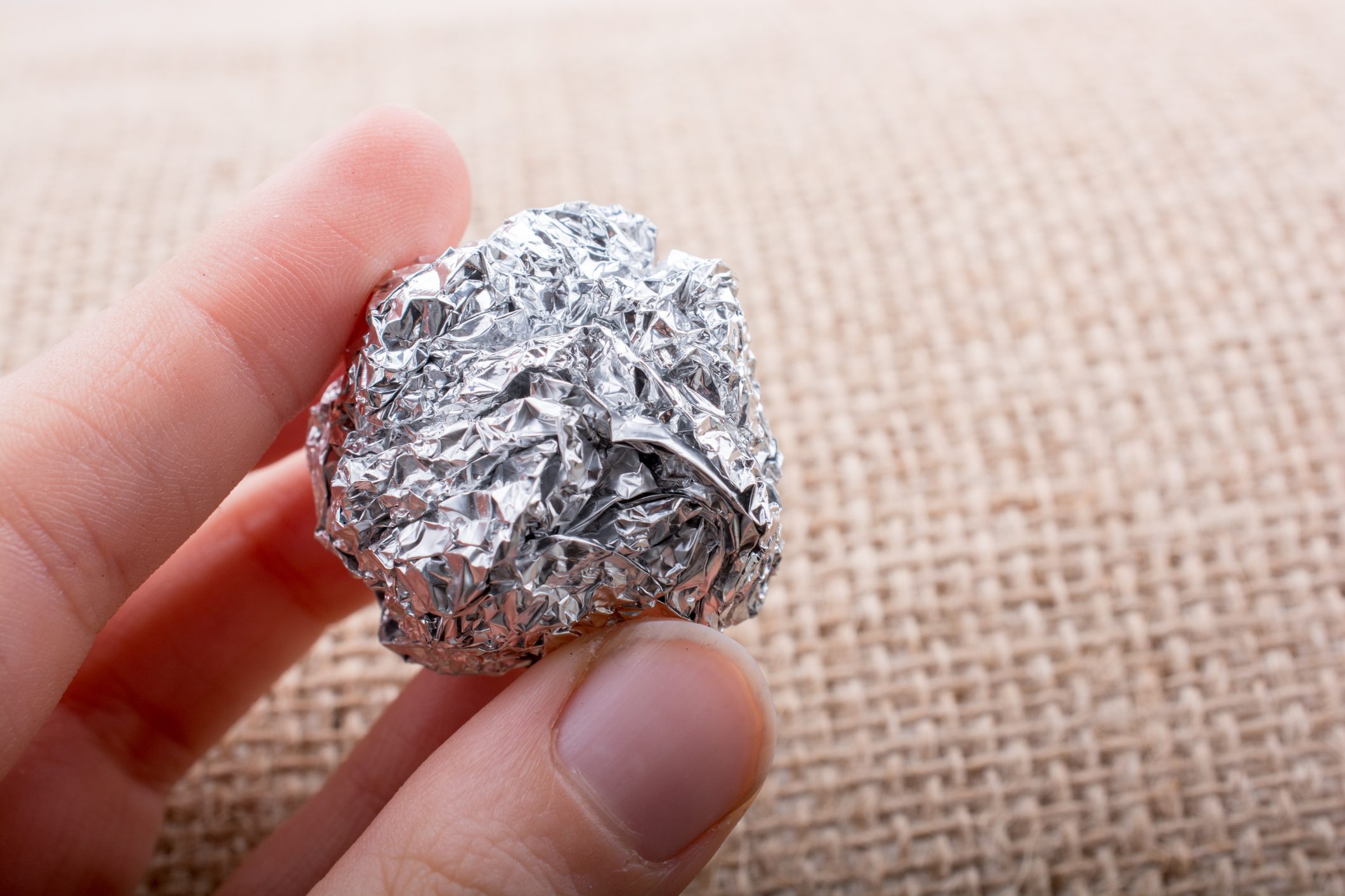 Aluminium foil in the shape of a sphere on textured background
