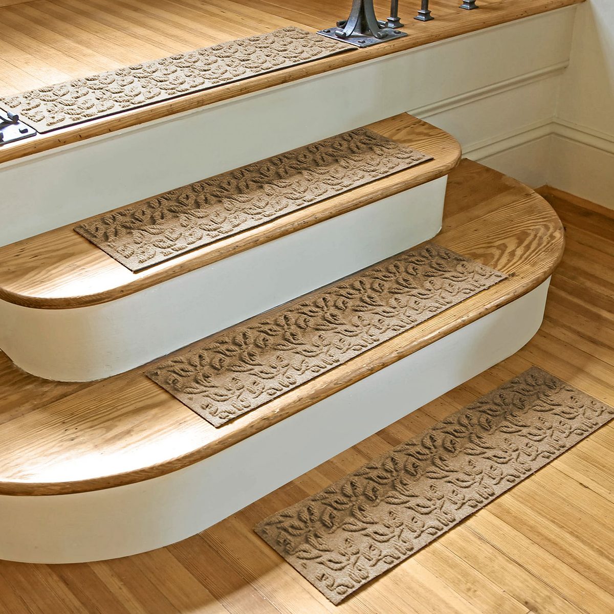 Textured runner mats are placed on wooden stair treads, providing traction and comfort, within an indoor wooden environment, enhancing safety and aesthetics.