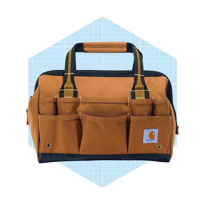 A sturdy, brown tool bag with multiple front pockets, held by two handles, is positioned against a light blue grid background.
