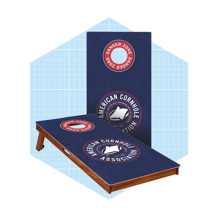 A cornhole board set displays a blue surface featuring logos. One board is upright while the other lies flat, appearing ready for gameplay.