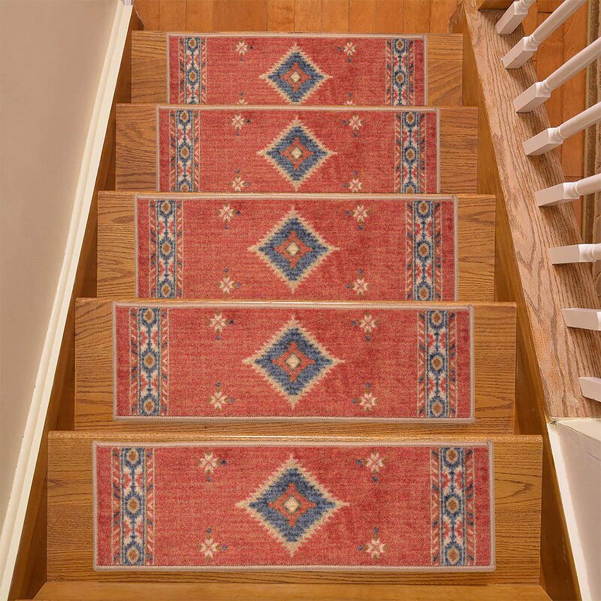 Decorative stair runners cover wooden steps, featuring a floral pattern with diamonds and blue accents, enhancing the staircase in a home environment.