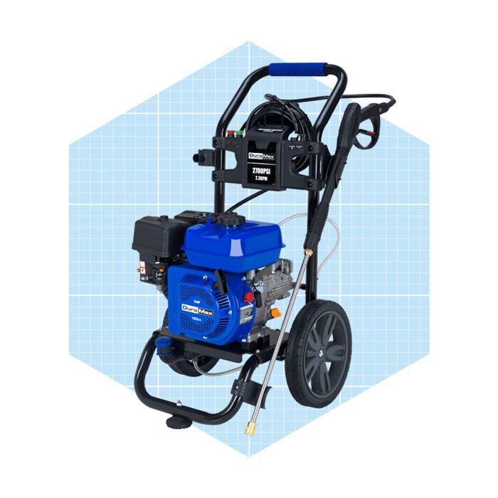 A blue pressure washer stands upright, featuring a hose and spray gun, positioned against a light blue, grid-patterned background. It is ready for use.