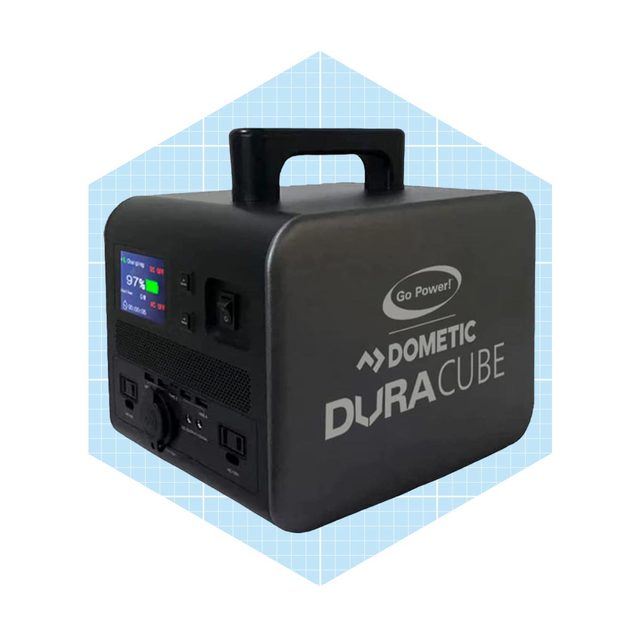 A compact black power station charges devices, displaying energy status on a screen, and is designed for portable use with a top handle.