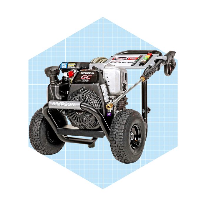 A pressure washer with wheels and a Honda engine is positioned against a light blue grid background, showcasing its controls and nozzle attachments.