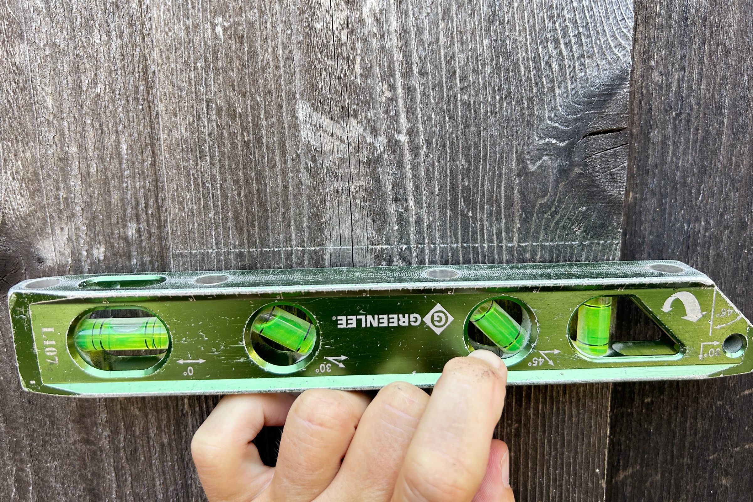 using a level on the fence before cutting the hole