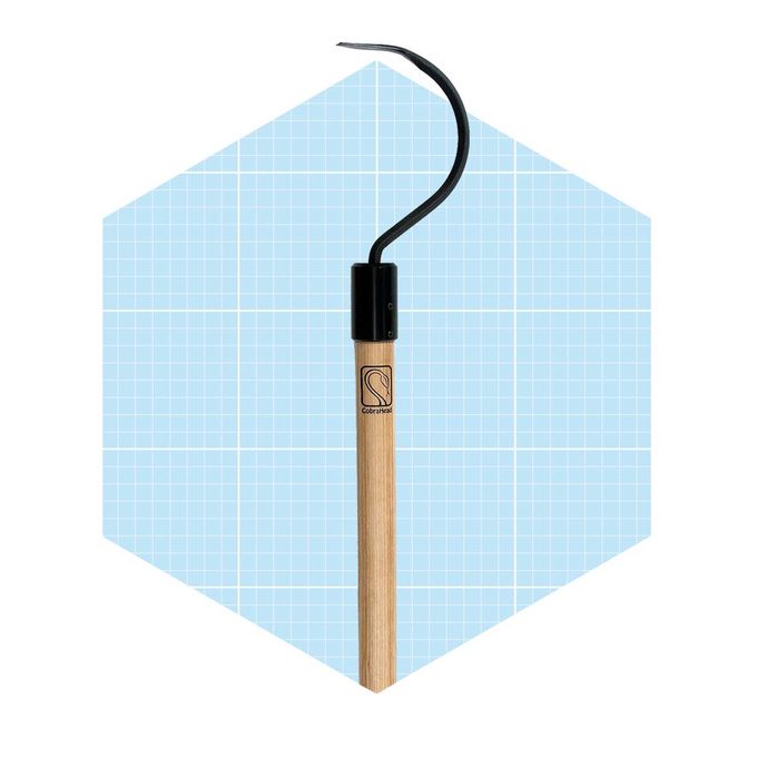 A wooden-handled tool with a curved metal hook is displayed against a light blue grid background. It appears designed for gardening or crafting tasks.