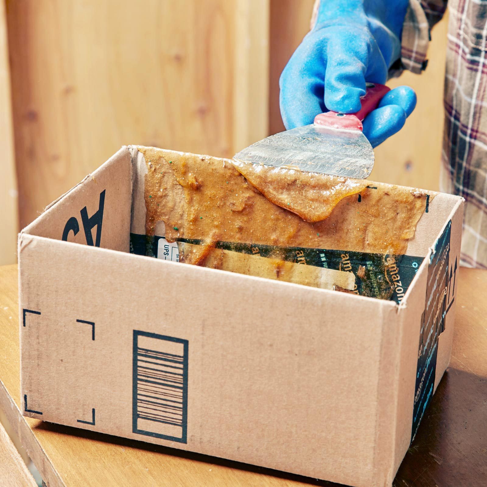 scrap spatula on cardboard box to clean it off