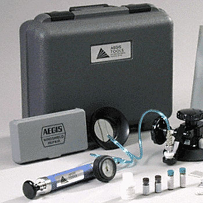 A gray tool case sits on a table, surrounded by various instruments and vials, indicating a repair or maintenance activity.
