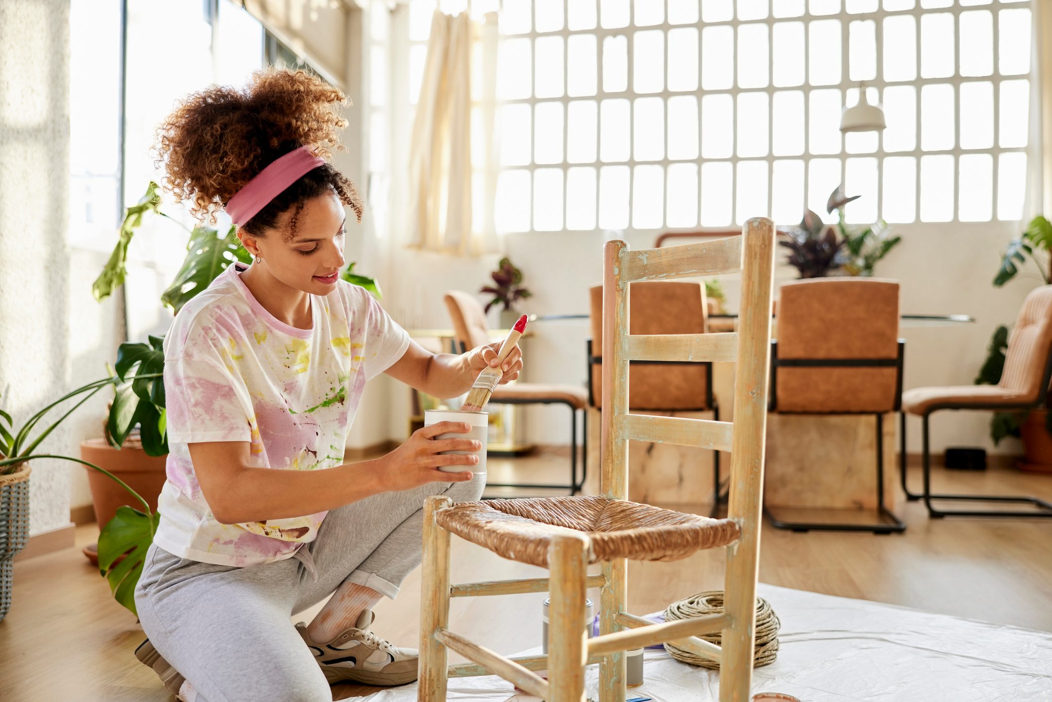 Smiling Young Female Painting Chair At Home