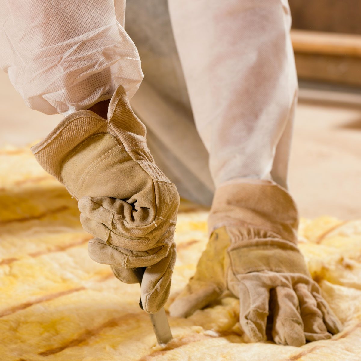 Man Cutting Insulation Material For Building insulation Construction