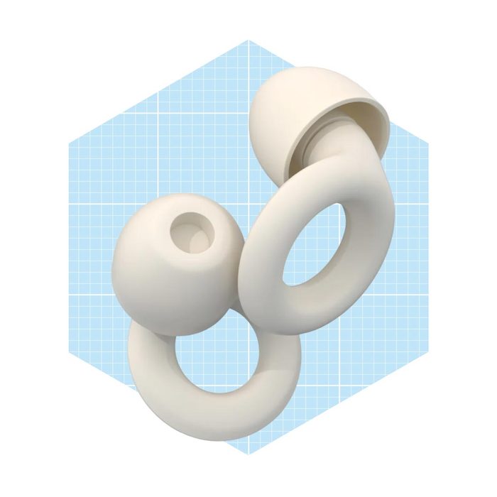 A pair of white earbuds rests against a light blue grid background, showcasing their rounded design and smooth contours.