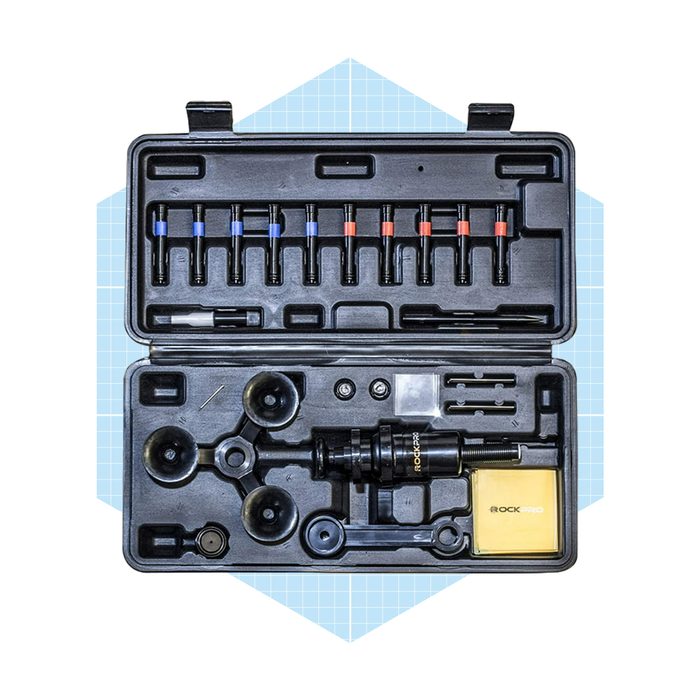A black tool case contains various tools, including suction cups and adapters, organized neatly for mechanical or assembly tasks on a light blue background.