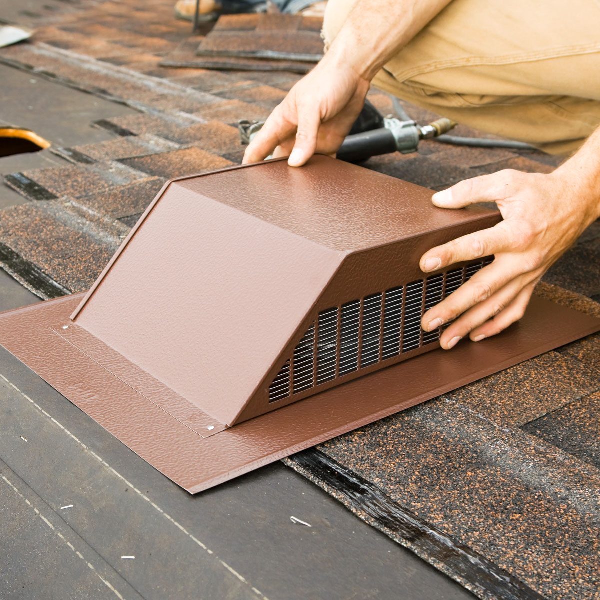 Installing Attic Vent On Home Roof Replacement Project