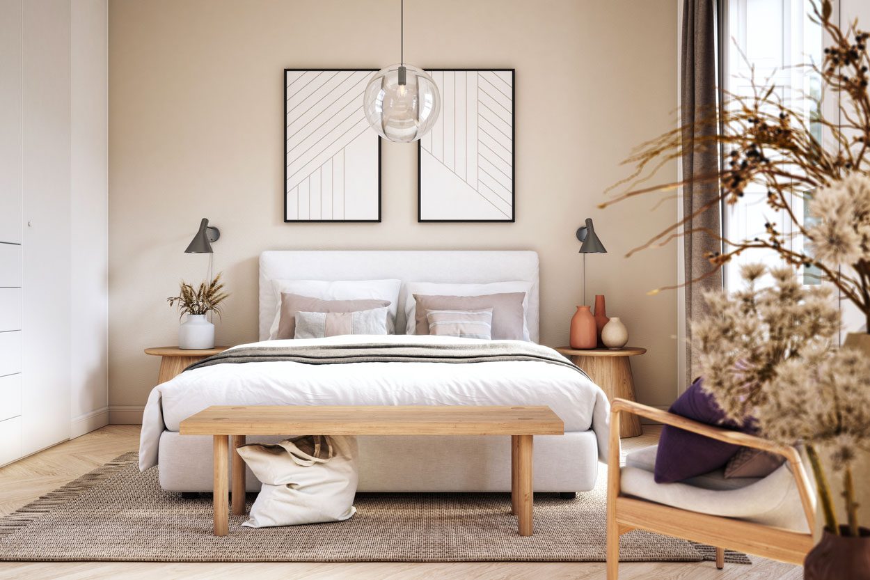 A cozy bedroom features a bed with soft pillows, a wooden bench, and decorative elements, illuminated by pendant lights amidst neutral tones and natural materials.