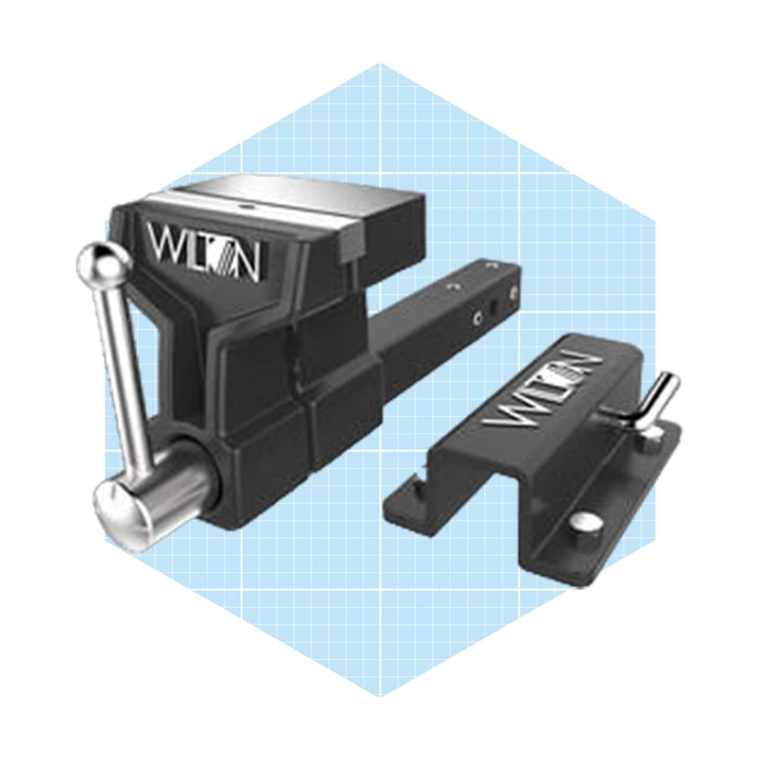 A black vise with a silver handle is positioned against a light blue grid background, designed for securing objects during work.