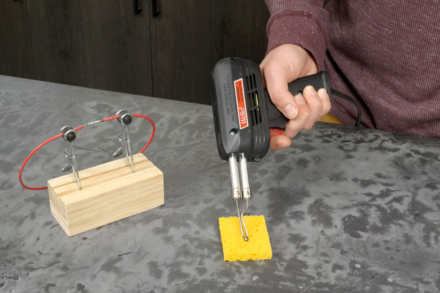 Wiping the solder gun tip with sponge