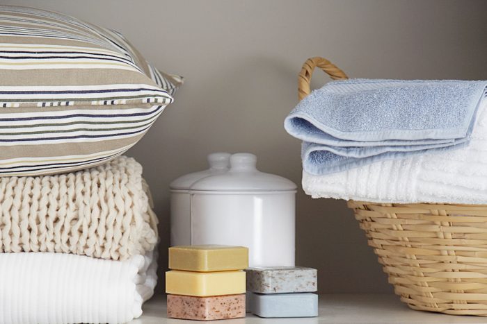 Bars of Homemade, Natural Soap Rest in a Linen Closet surrounded by pillows, blankets, sheets and towels