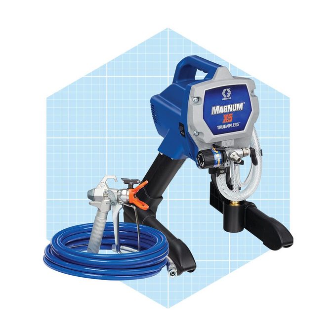 A blue airless paint sprayer rests on a surface, with a hose coiled nearby, ready to spray paint in various projects.