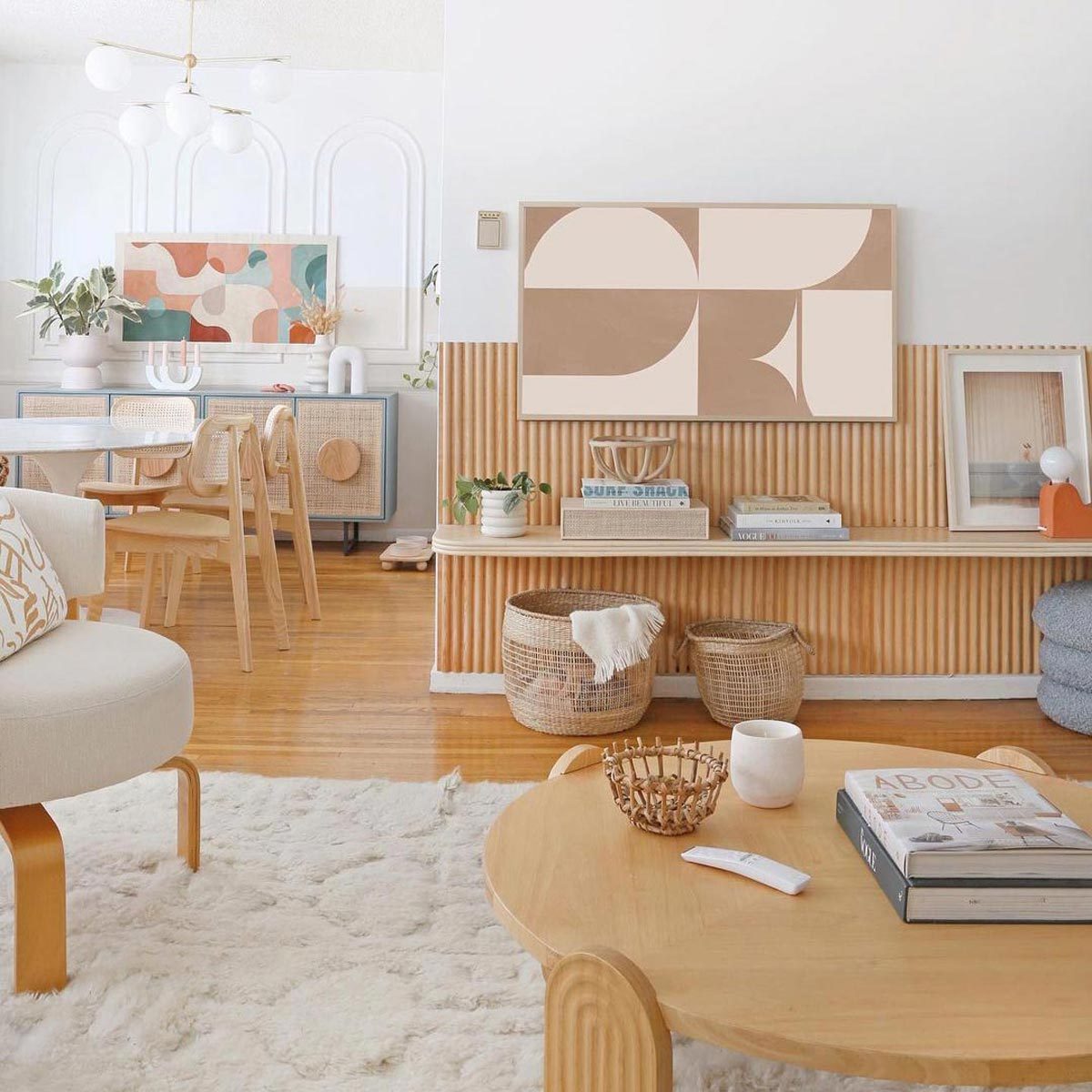 A living room with a white rug and wooden furniture