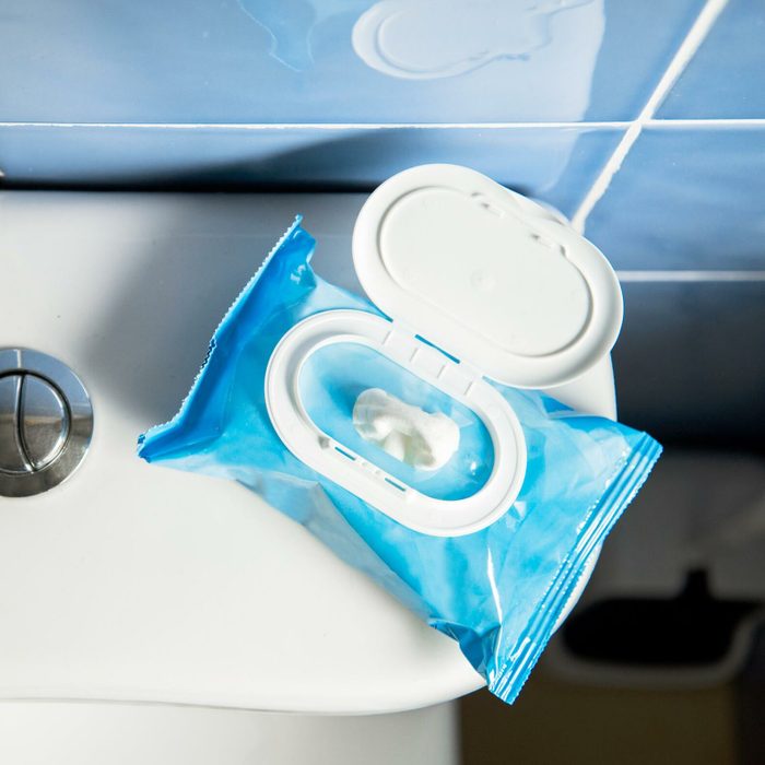 flushable wipe package on the back of a toilet