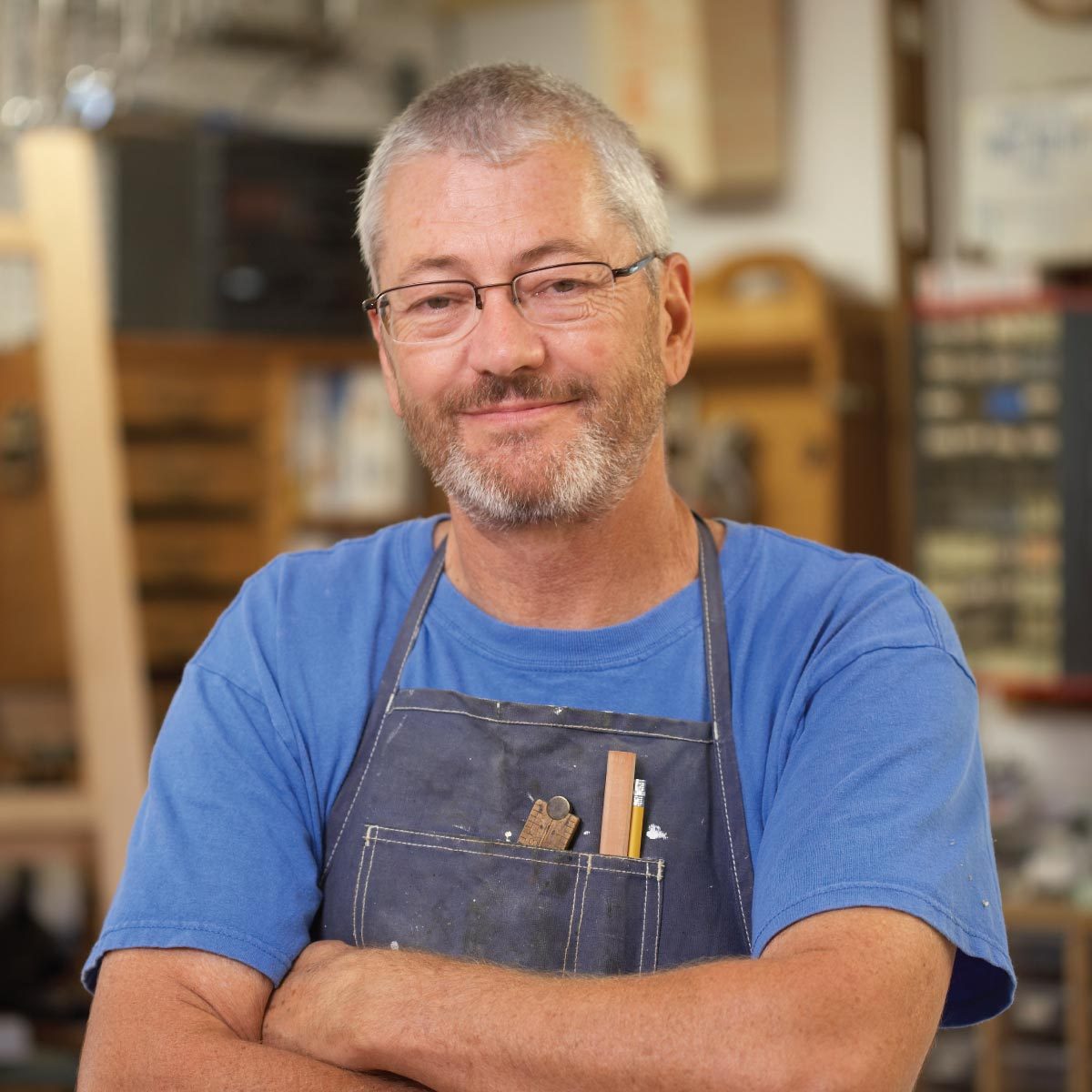 Dave Munkittrick in a blue apron with his arms crossed.