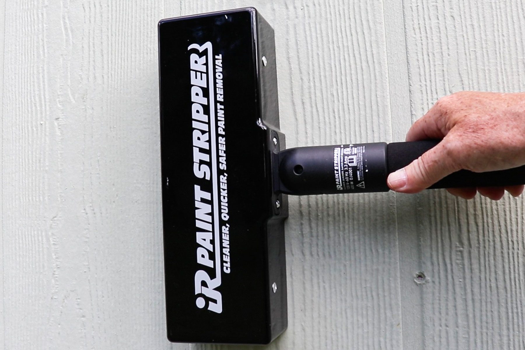 A person holding spengar to remove the paint