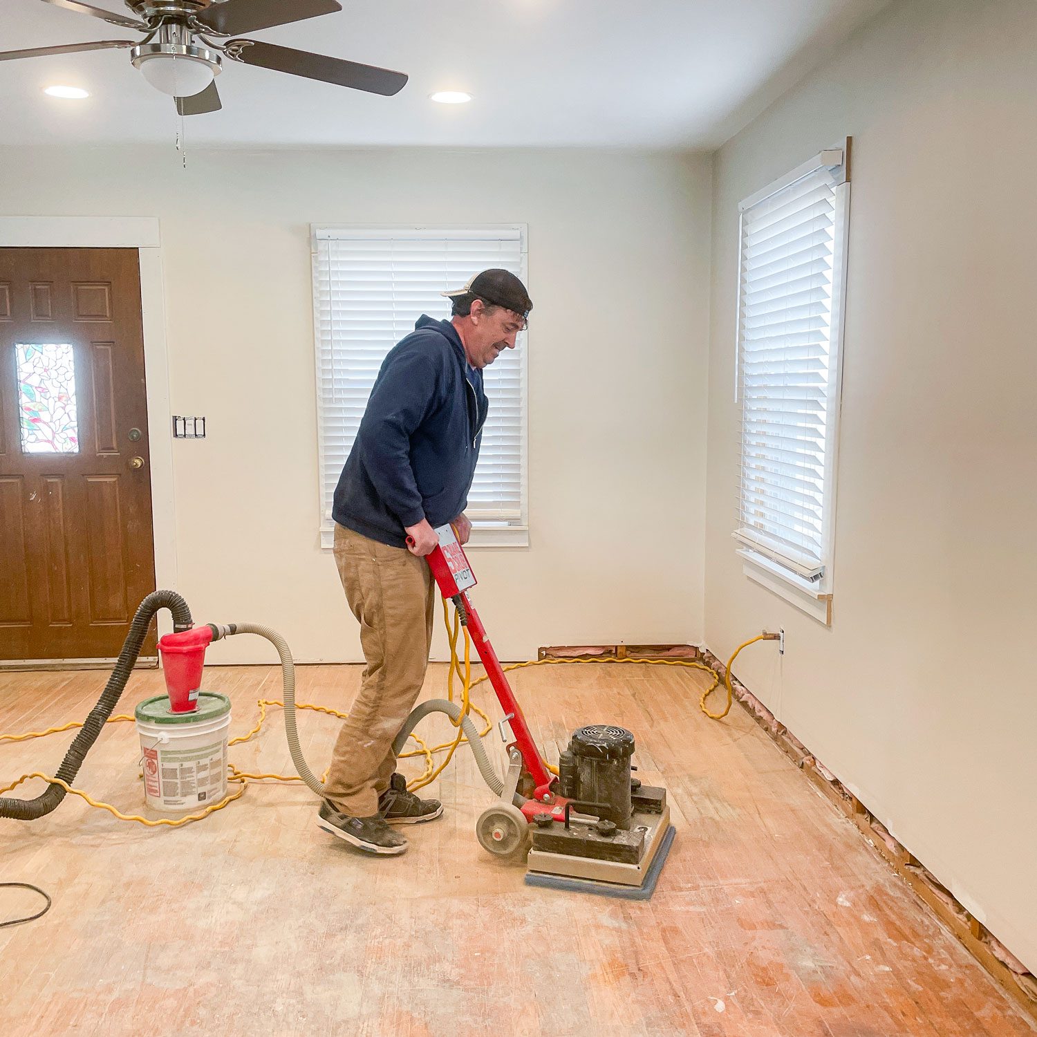 A Person Sanding Hardwood Floor with Floor Sanding Machine