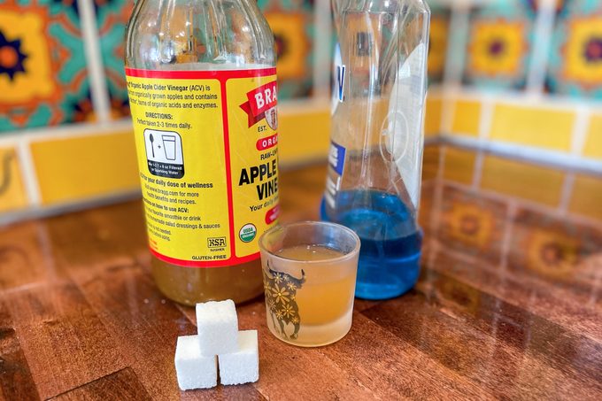 A bottle of apple cider vinegar and sugar cubes