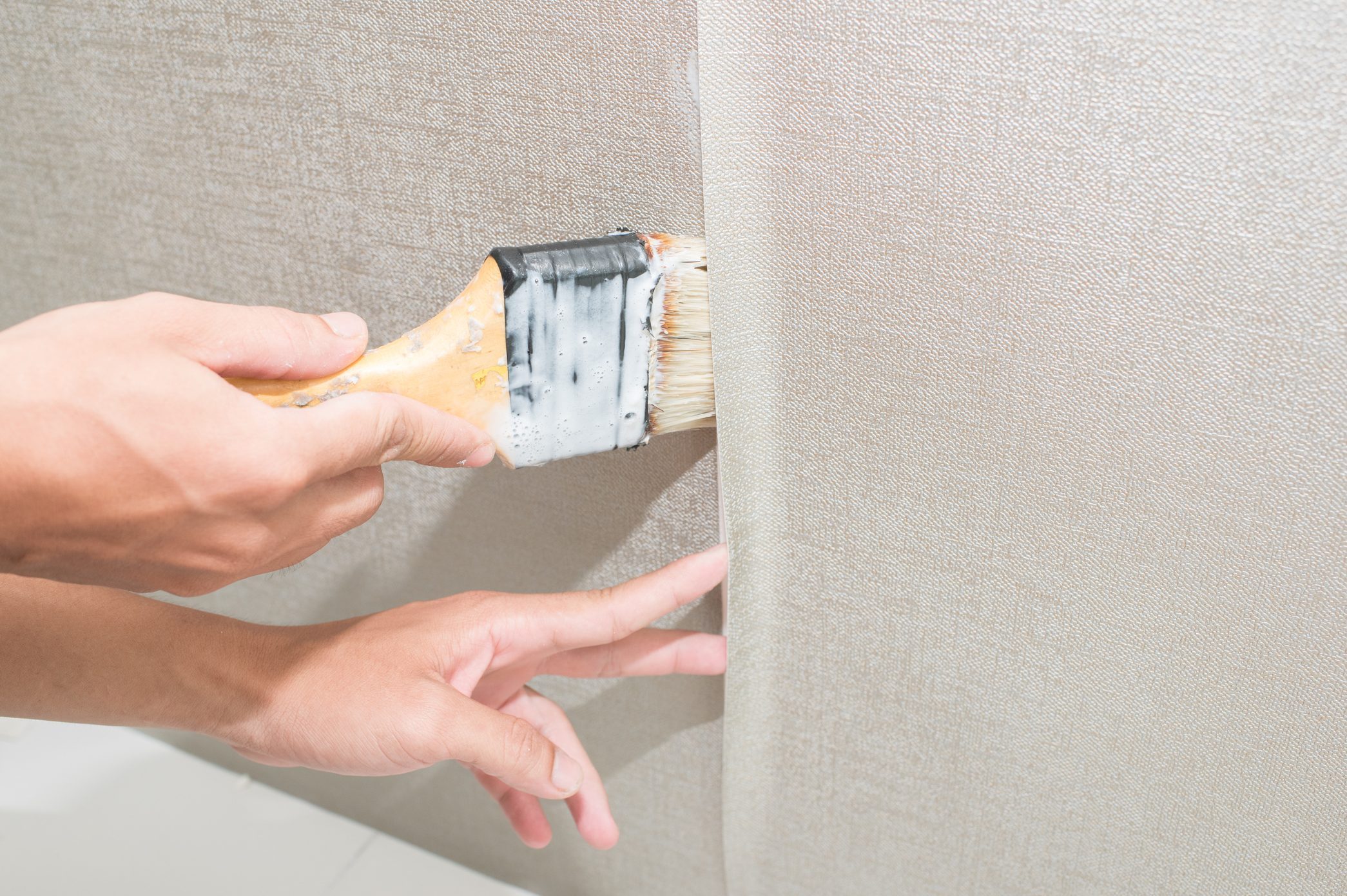 Handyman glueing the wallpaper