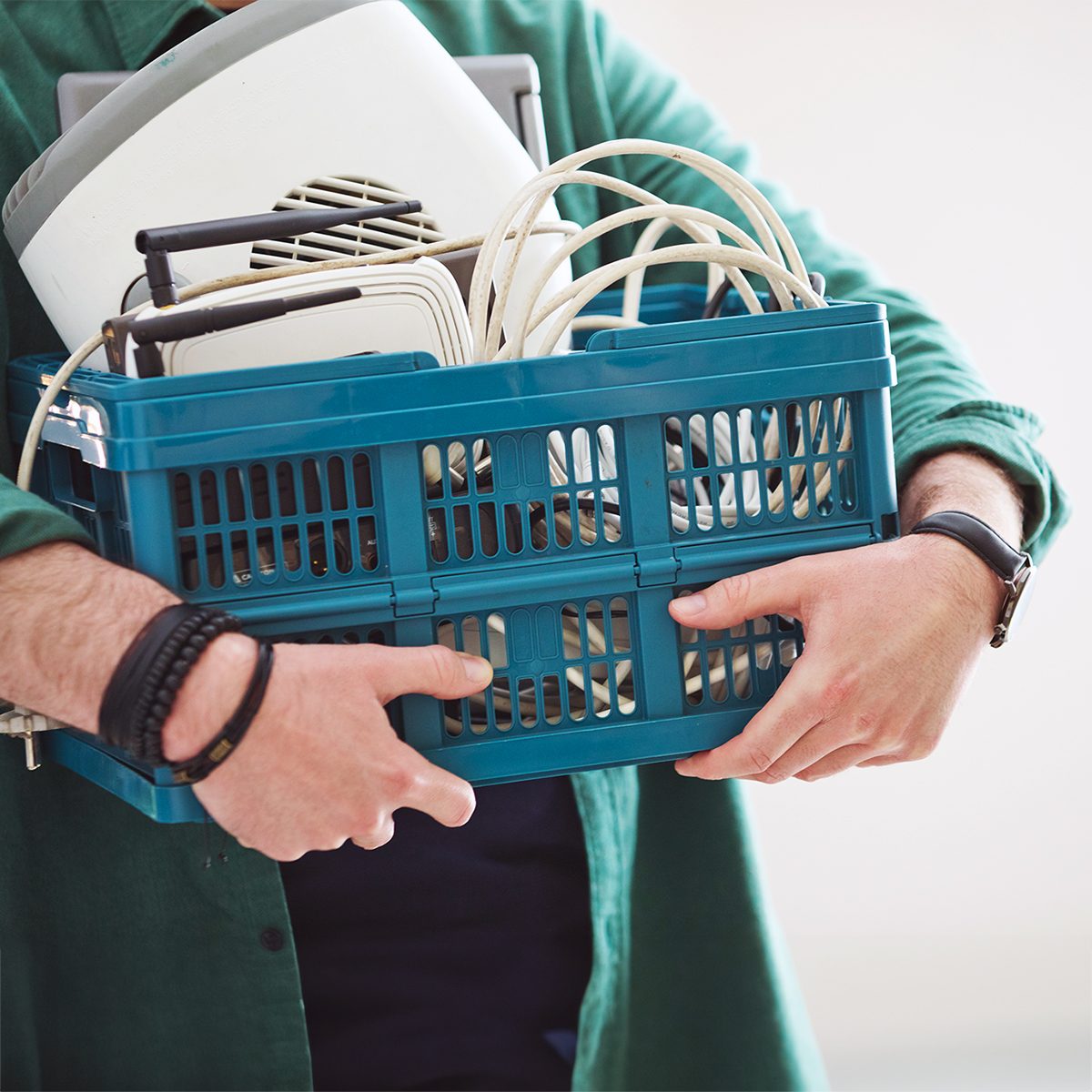 Man holding basket with electronic waste