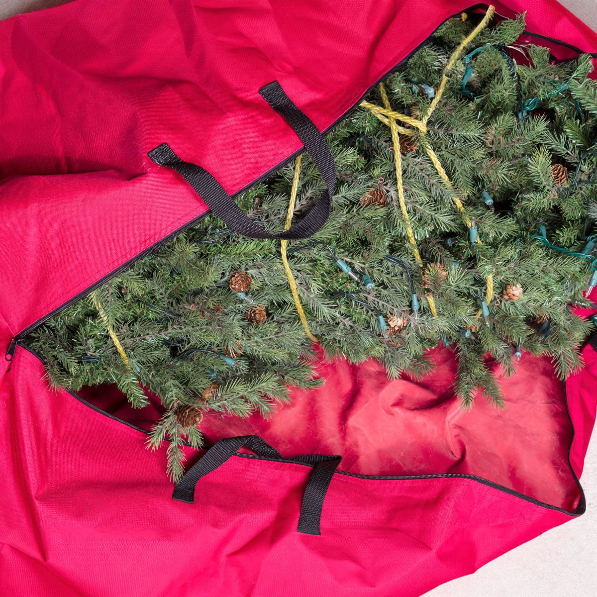 Large Artificial Christmas Tree Being Placed In Red Nylon Zipper Bag Gettyimages 177712166 Ksedit