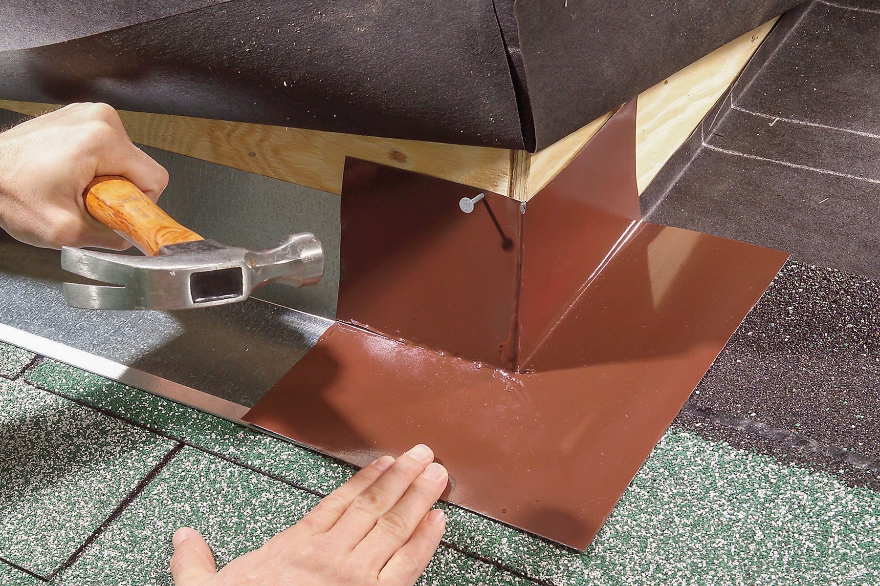 Hands can be seen nailing flashing on base flashing.