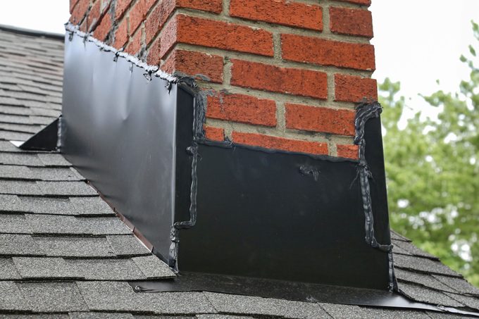 Flashing under a chimney on a roof.