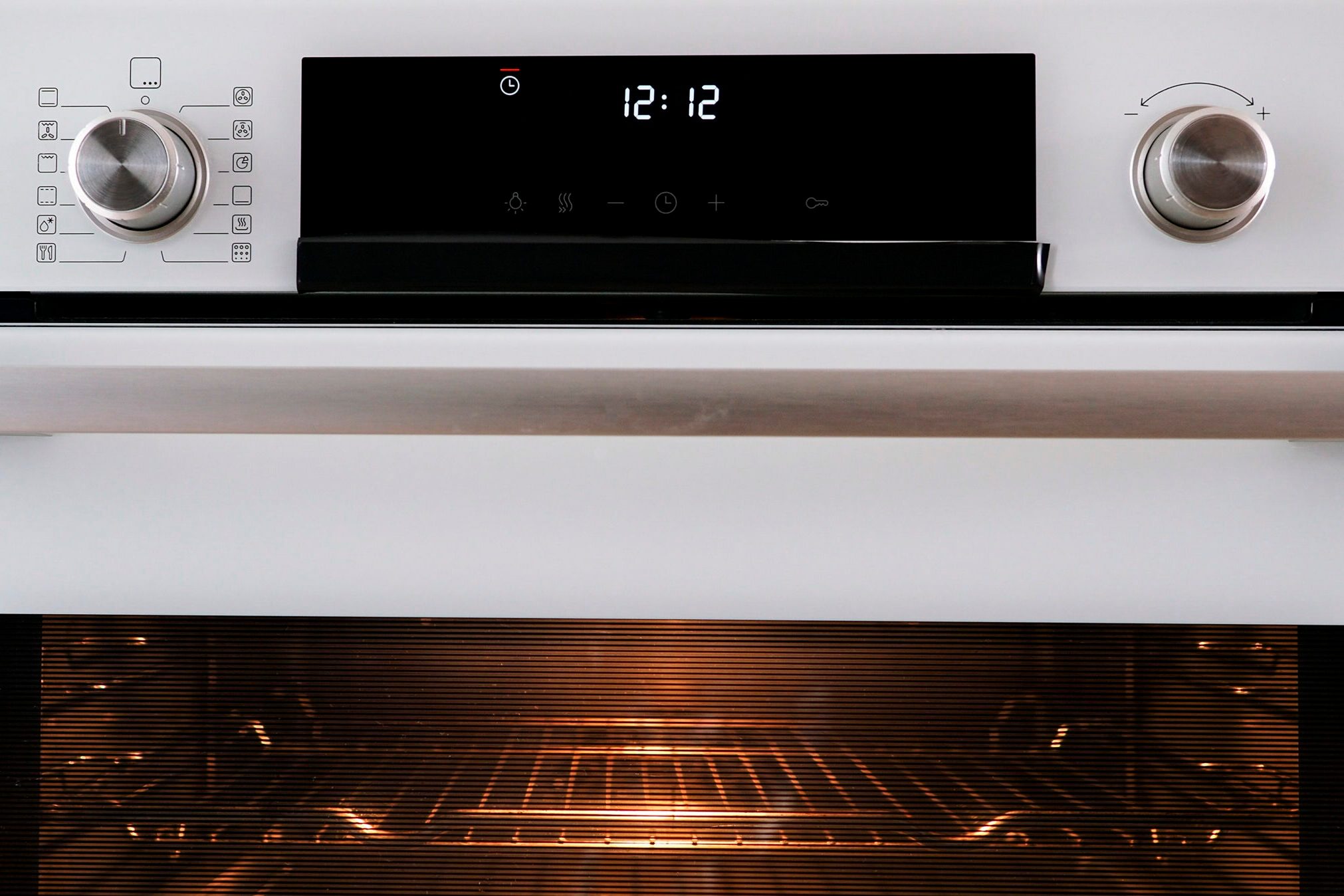 Buttons and control panel of a modern oven with the clock timer flashing.