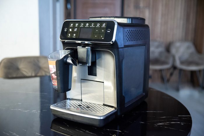 Modern automatic coffee machine on kitchen table