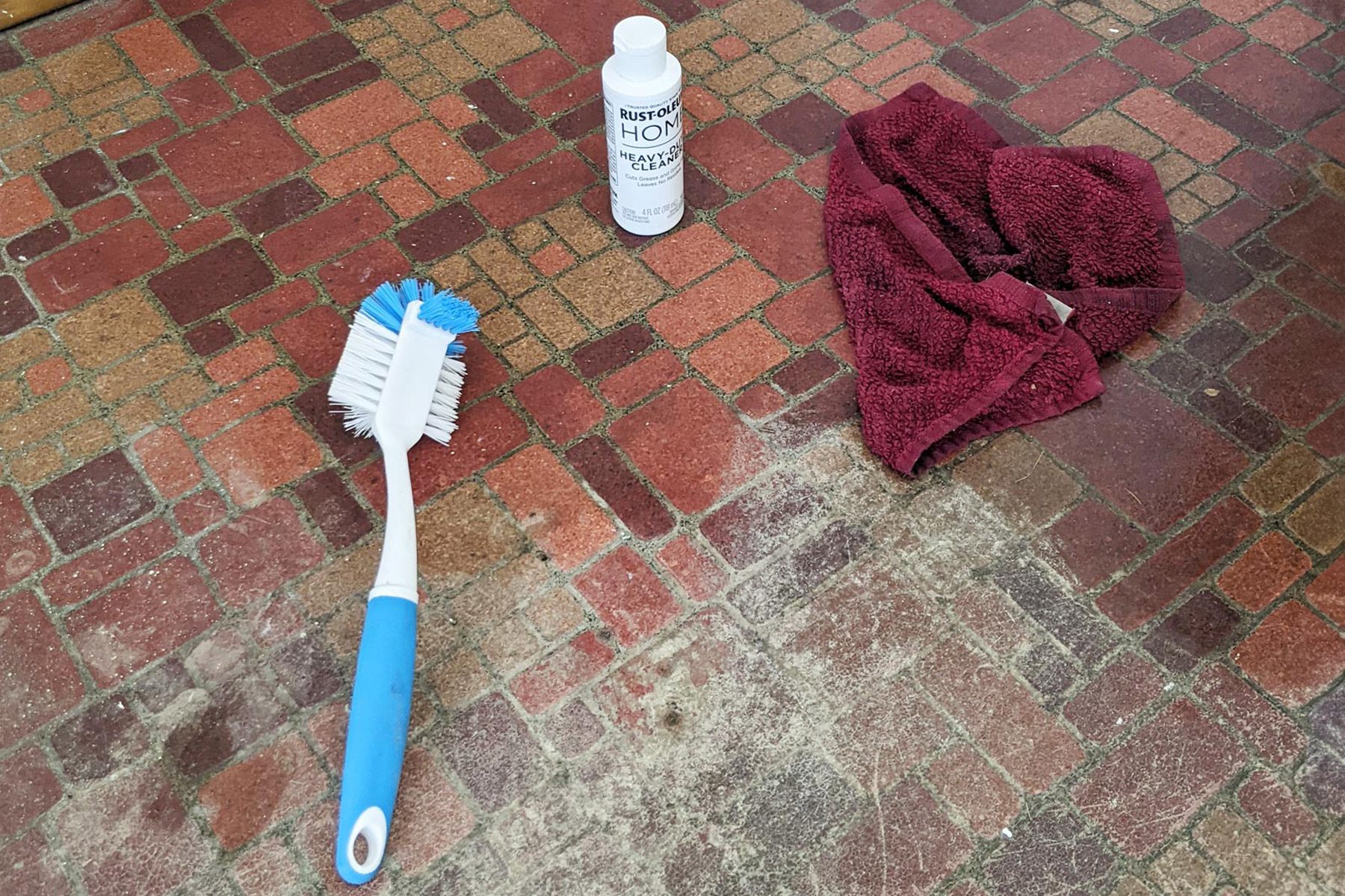 Rag, cleaning brush and cleaning agent on vinyl floor.