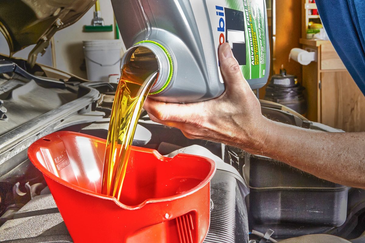 pouring motor oil in car engine
