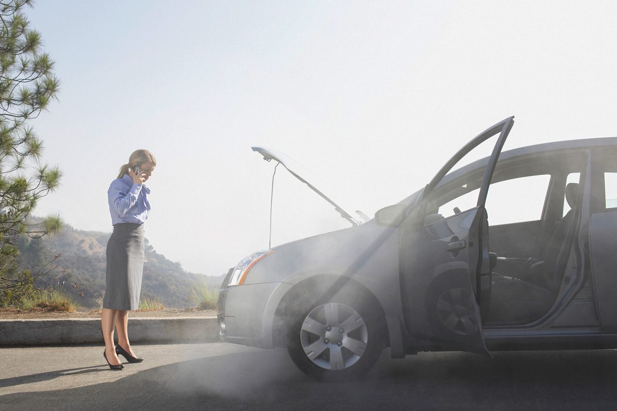 woman calling for assistance for car stalled on side of the road