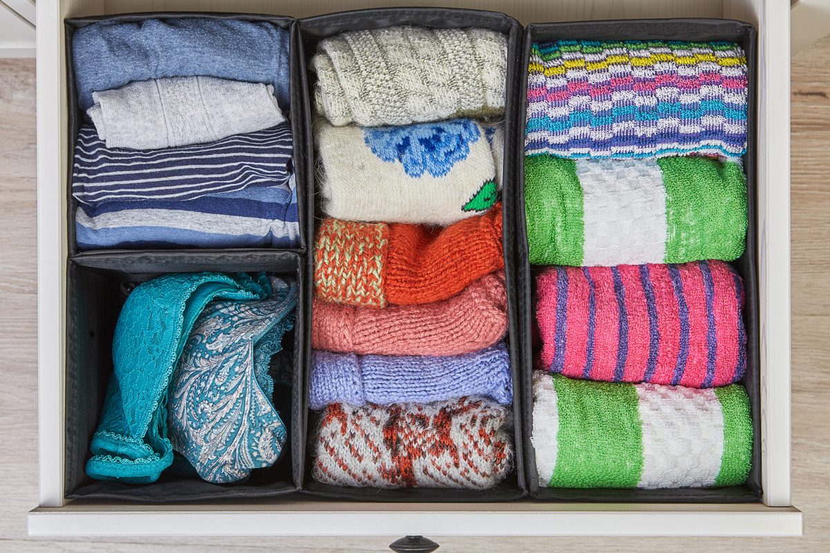 The drawer of the cabinet is divided into compartments using boxes of different sizes
