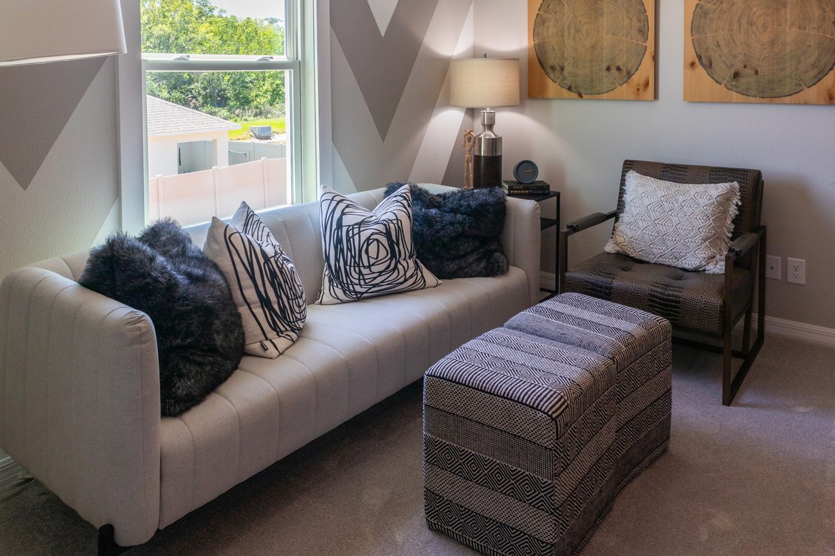 living room area with armchair, sofa and ottoman