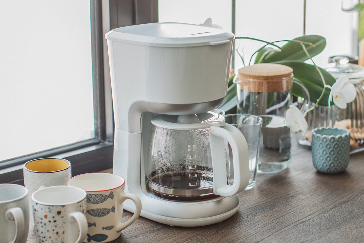 counter with coffee machine and mugs in living room