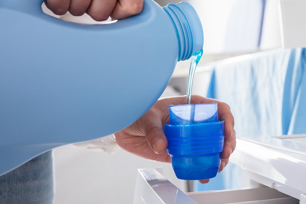 A person is pouring liquid detergent