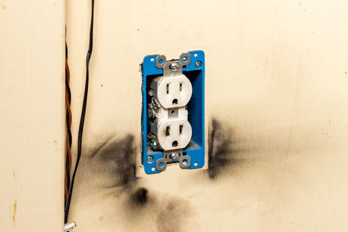 Electrical Outlet With Burn Marks On Wall From Short Circuit Gettyimages 1486103371