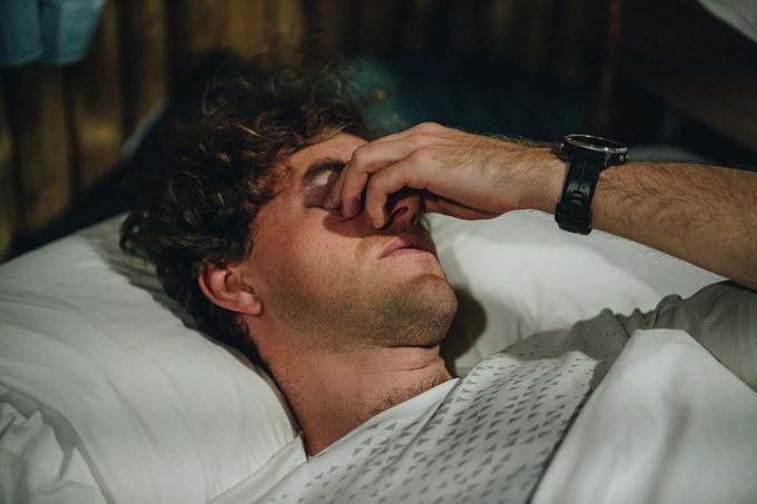 Portrait of young man groggily waking up in the morning