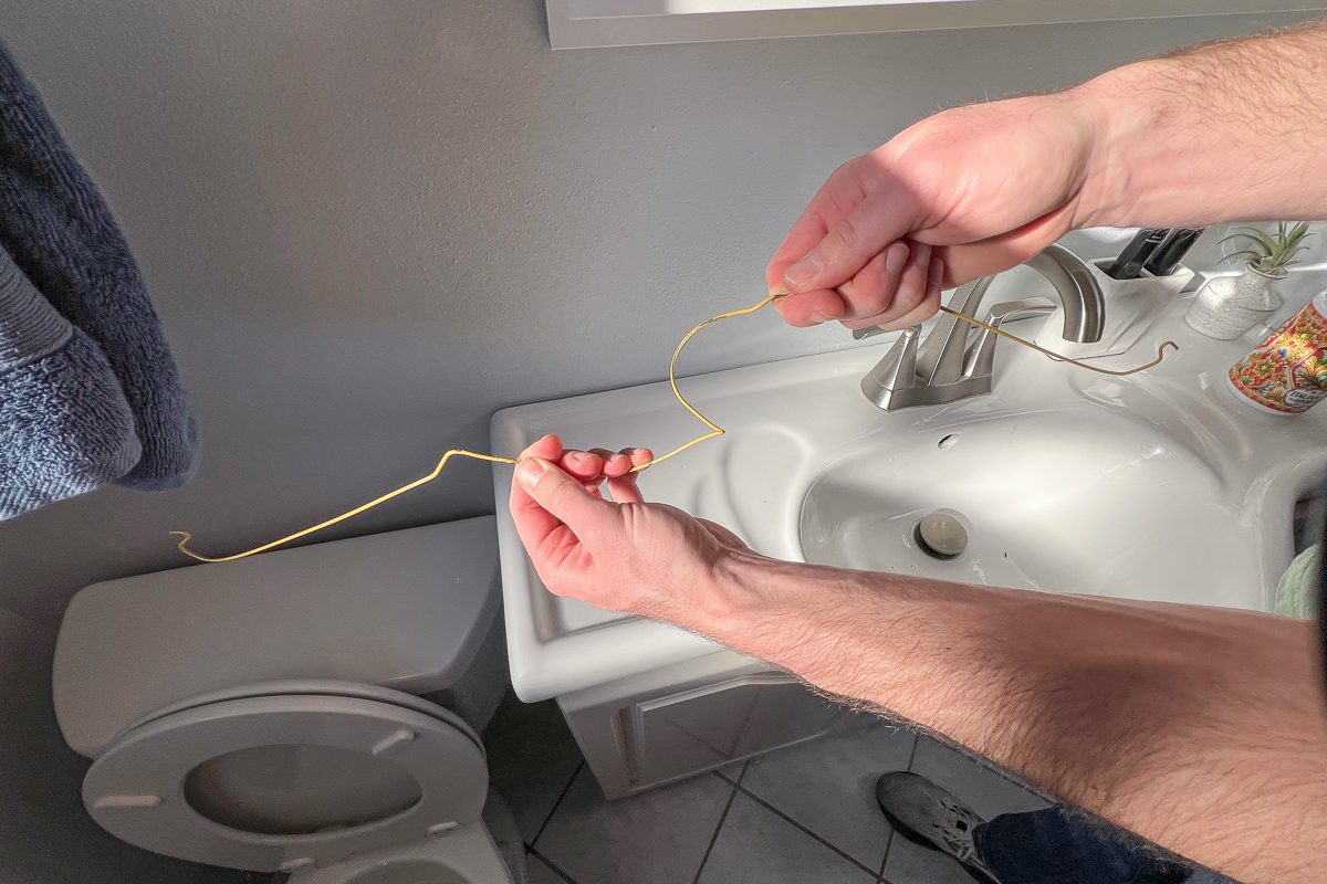 straightening out a wire coat hanger