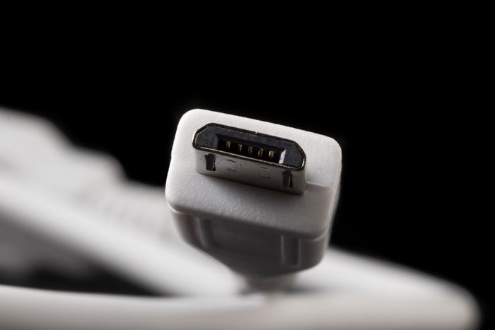Micro USB type B or USB-B plug and white cable close-up.